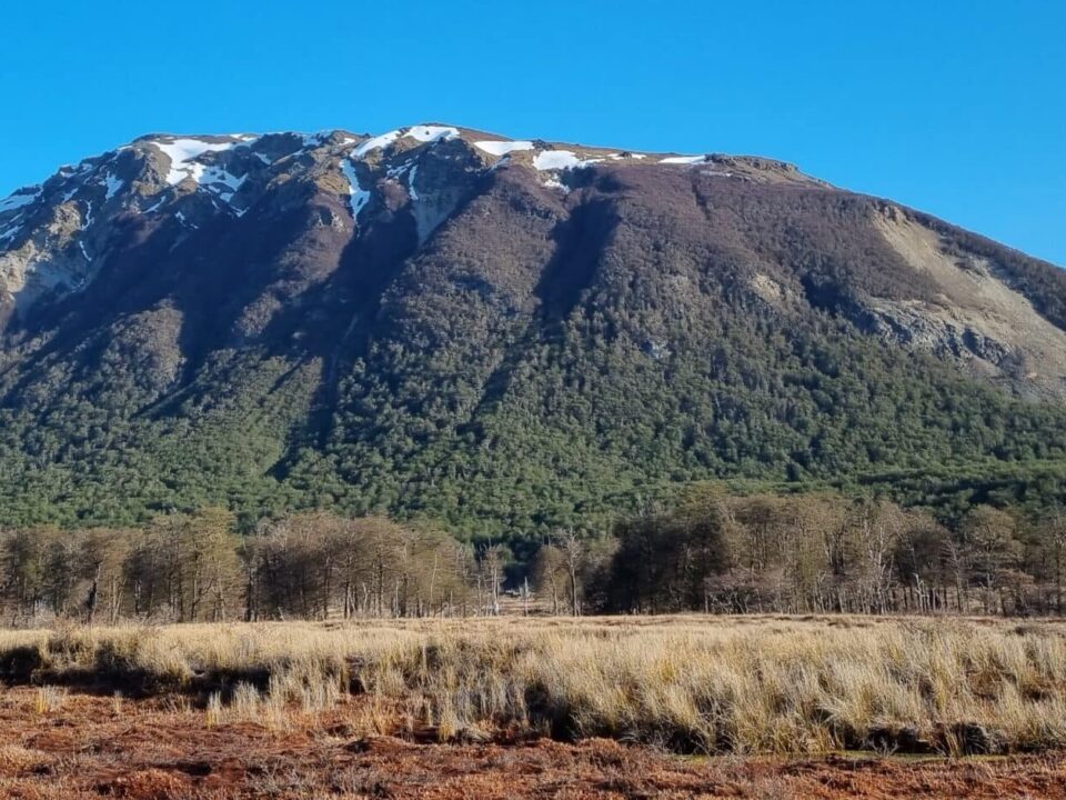 Imagen de una montaña junto a un turbal con un cielo celeste