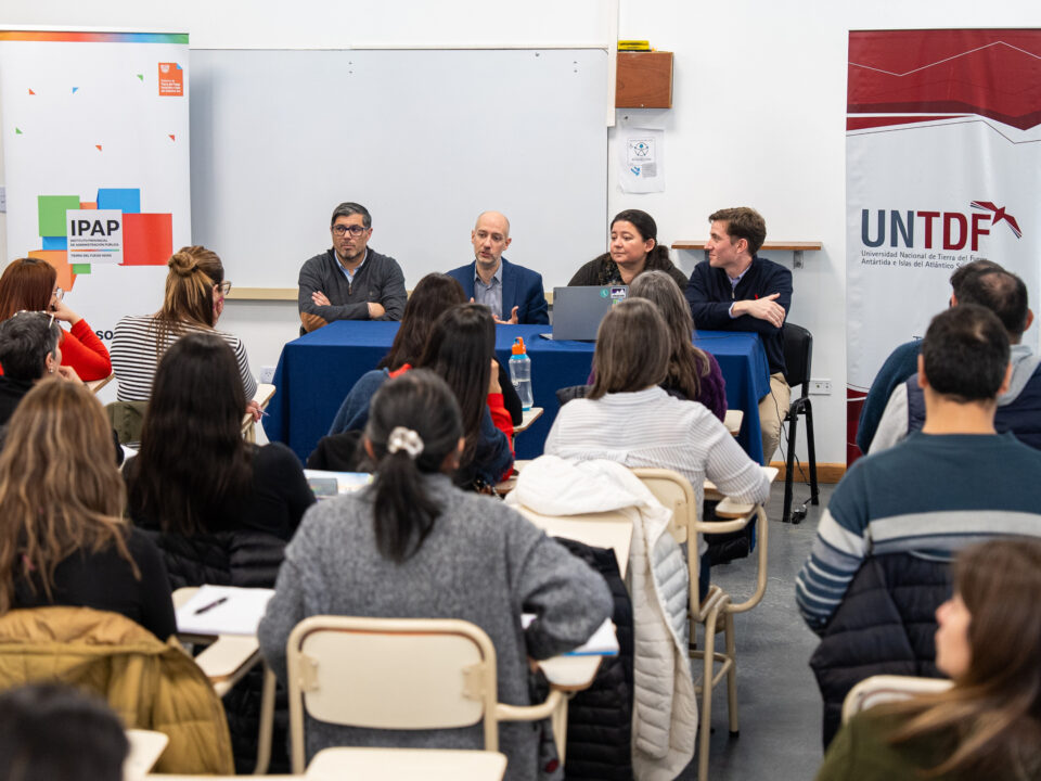 toma desde atrás en un aula de universidad, cuatro personas dando una conferencia