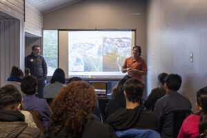 Dos hombres hablando frente a un público.